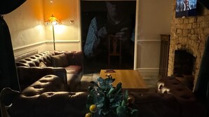 Un salon chaleureux avec un canapé en cuir, une table basse en bois et une petite plante en pot.