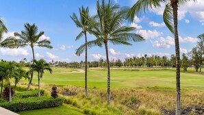 A golf course with palm trees and a clear sky.