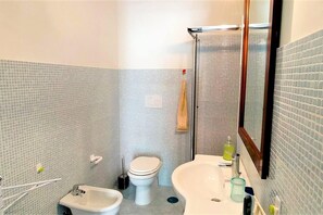 Un baño con bidé, inodoro y lavamanos.