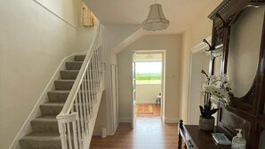 A staircase with white railings leading to a landing, a wooden piano, and a mirror on the right. - Beautiful Irish Farmhouse an Hours Drive From Four Irish Cities (Clonmel)