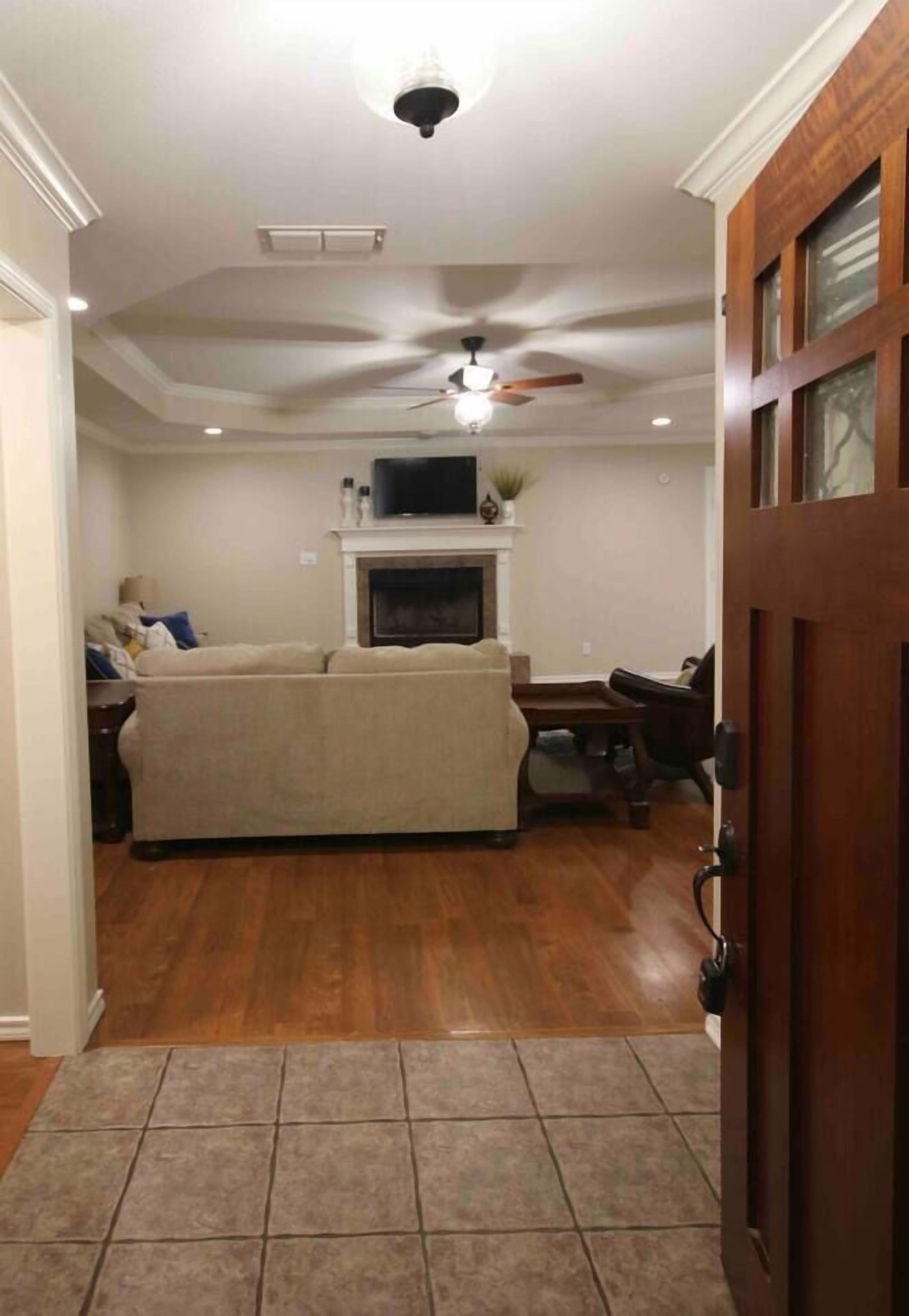 A living room with a beige sofa, a television, and a fireplace.
