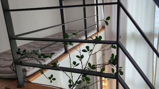 A metal staircase with a cushioned bench at the bottom.