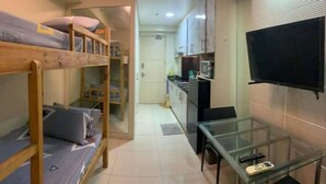 A compact studio apartment with a bunk bed, kitchenette, and a small dining area. - Sea Resi.MoA.Airport Netflix (Pasay)