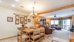 A spacious living area with a wooden dining table, leather sofas, and a chandelier. - Seven Springs Stoneridge 3 BR Condo, Private Deck by RedAwning (Champion)