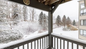 A covered balcony with a view of a snowy landscape and trees. - Seven Springs Stoneridge 3 BR Condo, Private Deck by RedAwning (Champion)