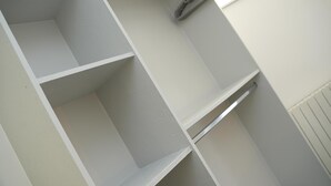 A white closet with open shelves and a hanging rod. - Charming 1-bed & Balcony Flat in Merthyr Tydfil (Merthyr Tydfil)