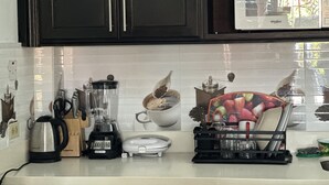 A kitchen with a blender, kettle, and coffee maker on the counter. - Remarkable 1-bed Apartment in Montego Bay (Montego Bay)
