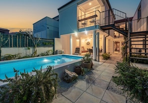 A modern two-story house with a swimming pool, outdoor seating area, and a staircase leading to a balcony. - Villa Jelić (Nin)
