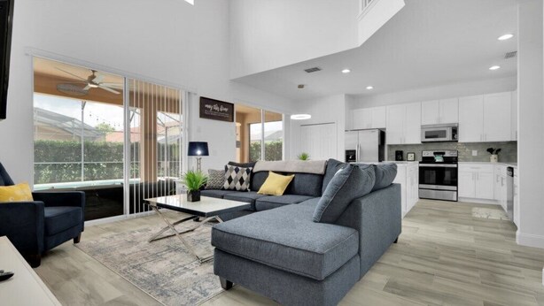 A modern apartment with a living area, kitchen, and balcony.