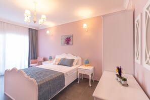 Een slaapkamer met een bed, nachtkastjes, een stoel en een bijzettafeltje met planten.
