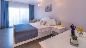 A modern bedroom with a large bed, bedside tables, a nightstand, and a view of the city through large windows. - Lavinya Selimiye Buotique Hotel (Marmaris)