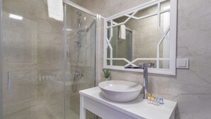 A bathroom with a glass-enclosed shower, a white sink with a bowl, and a mirror with a geometric frame. - Lavinya Selimiye Buotique Hotel (Marmaris)