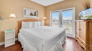 Ein Schlafzimmer mit einem großen Bett, einem Deckenventilator, einem Fenster mit Jalousien und einem Holzschrank.