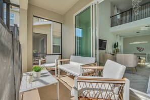 Een modern appartement met balkon, witte meubels en een keuken met groot raam.