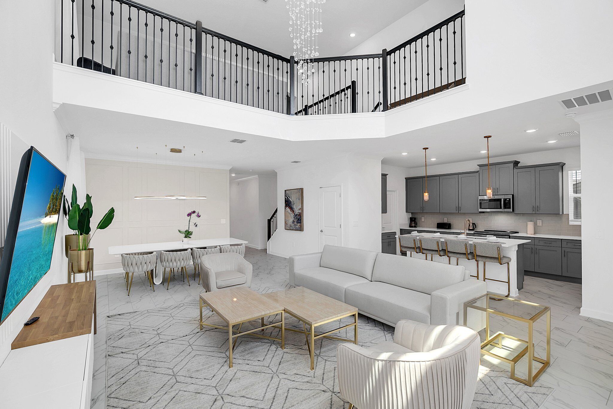 A spacious living area with a high ceiling, a dining set, a sofa, and a kitchen in the background.