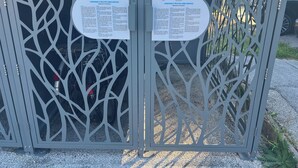 A metal gate with two informational signs attached to it. - Bright apartment for a pleasant stay in Hyères (Hyères)