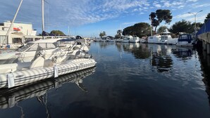 A marina with boats docked, a building with a sign, and trees in the background. - Bright apartment for a pleasant stay in Hyères (Hyères)