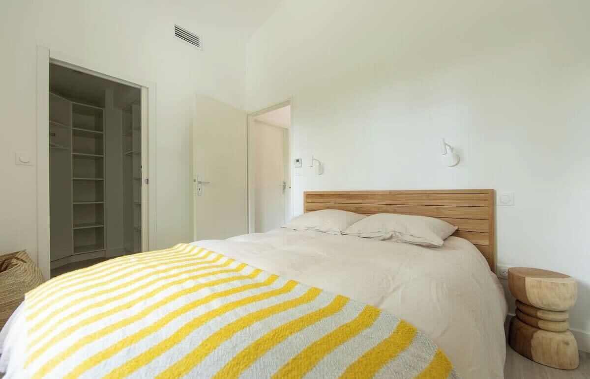A bedroom with a bed, a wooden headboard, a bedside table, and a wardrobe.