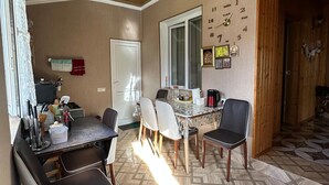Un comedor con techo de madera, piso de baldosas y un reloj de pared.
