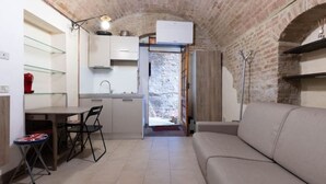 Un ambiente compatto con angolo cottura, zona pranzo e salotto.