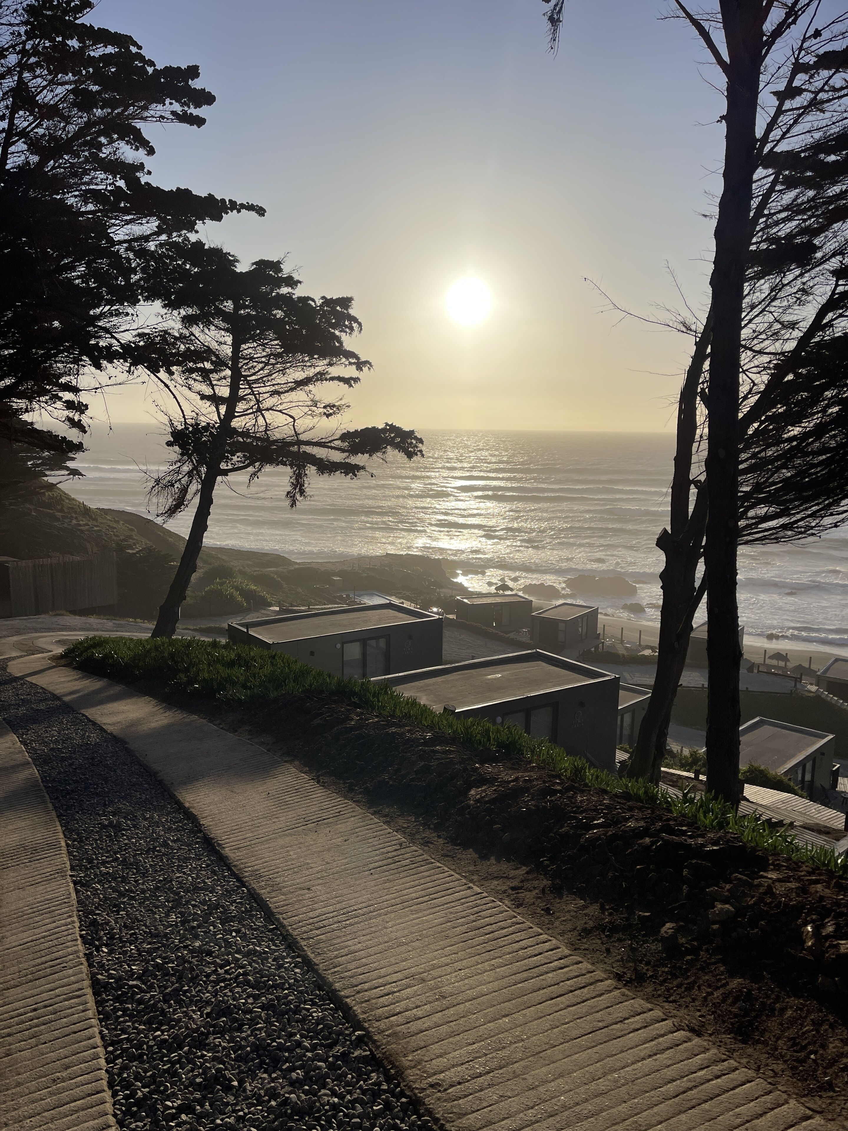 A coastal walkway with a view of the ocean and a clear sky.