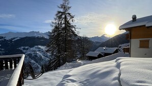A snow-covered mountain landscape with a wooden building and a wooden railing. - Arnold LUXE & COSY Chalet for 14 People in Les Masses (Les Masses)