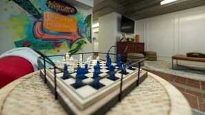 A chessboard in a room with a colorful mural on the wall and a sofa in the background. - Downtown Hideaway on trendy Denton square (Denton)