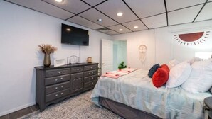 A bedroom with a bed, dresser, and a flat-screen TV mounted on the wall. - Downtown Hideaway on trendy Denton square (Denton)