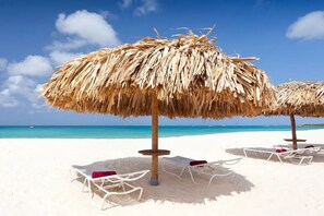 Plage, sable blanc, chaises longues, parasols