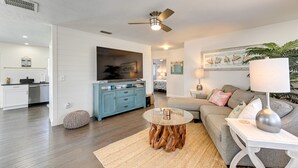 A modern living room with a grey sofa, a round coffee table, and a ceiling fan. - 4 Mi to Siesta Key Beach: Sunny Home w/ Hot Tub! (Sarasota)