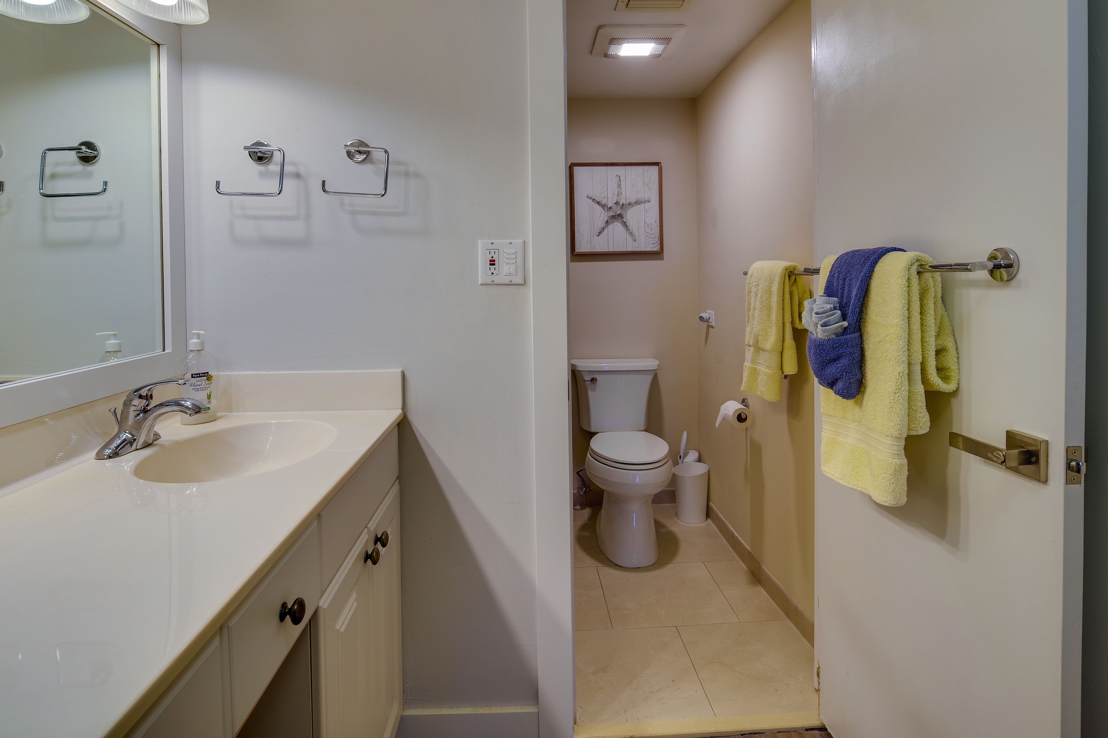 A bathroom with a sink, toilet, and towel rack.