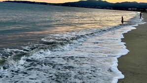 A beach with waves, a distant mountain range, and a cloudy sky. - Modern 2BR Golden Zone | Top Floor | Ocean View (Bucerias)