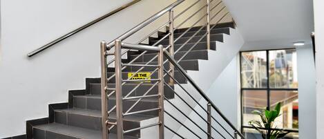 A modern staircase with metal railings and a sign that reads "USE THE LANDING."