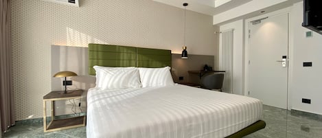 Una habitación de hotel moderna con una cama grande, un escritorio, una silla y un televisor.