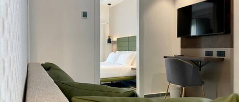 Una habitación de hotel con cama, escritorio y televisor.