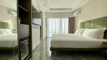 Une chambre d’hôtel avec deux lits, une télévision et un minibar.