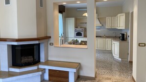 Una cocina moderna con gabinetes blancos, horno empotrado y cafetera sobre la encimera.