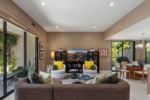 A modern living room with a sofa, coffee table, and bookshelves.