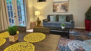 A living room with a sofa, coffee table, and decorative mats. - CHARMING INDEPENDENT GUEST HOUSE (West Palm Beach)