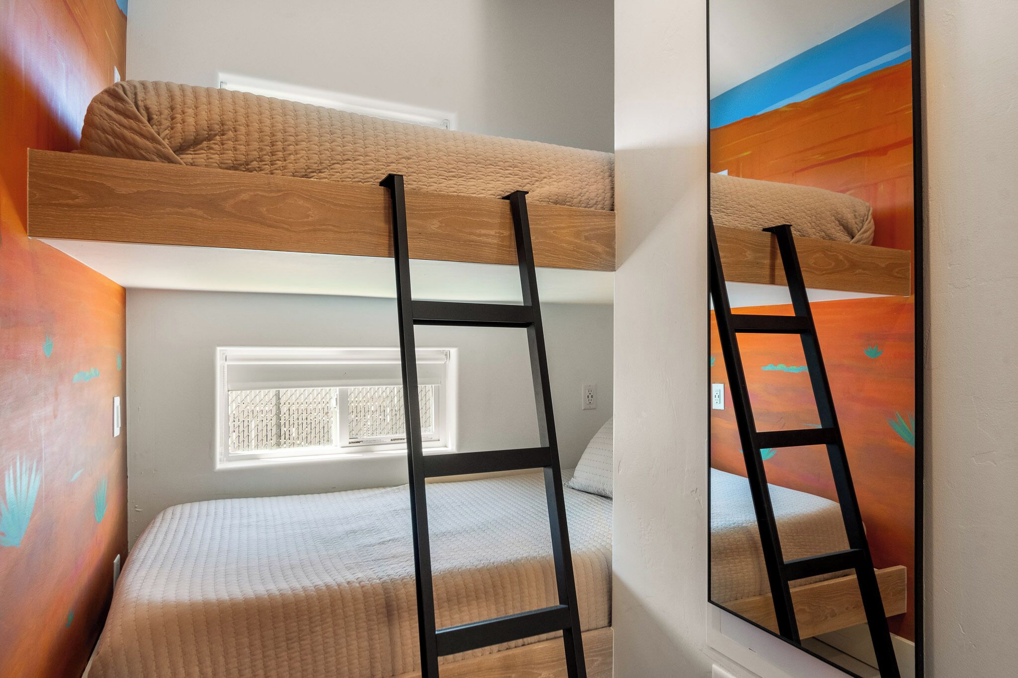 A bunk bed with a wooden ladder, a window, and a wall with a textured pattern.