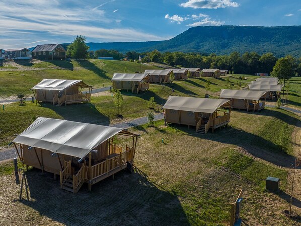 A campsite with multiple tents, each with a wooden deck and a covered area.