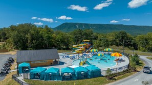 A water park with a large pool, slides, and umbrellas.