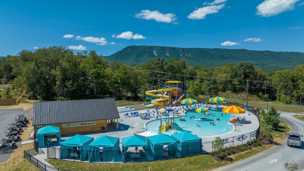 A water park with a large pool, slides, and umbrellas.