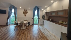 A modern kitchen with white cabinets, a wooden countertop, and a built-in oven. - Lovely Mountain Apartment Zakopane 14km (Suchá Hora)