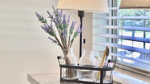 Un comptoir de cuisine avec une lampe, un vase de fleurs et un carnet.