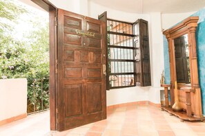 Una puerta de madera con un ventanal, una cortina azul y un armario de madera.