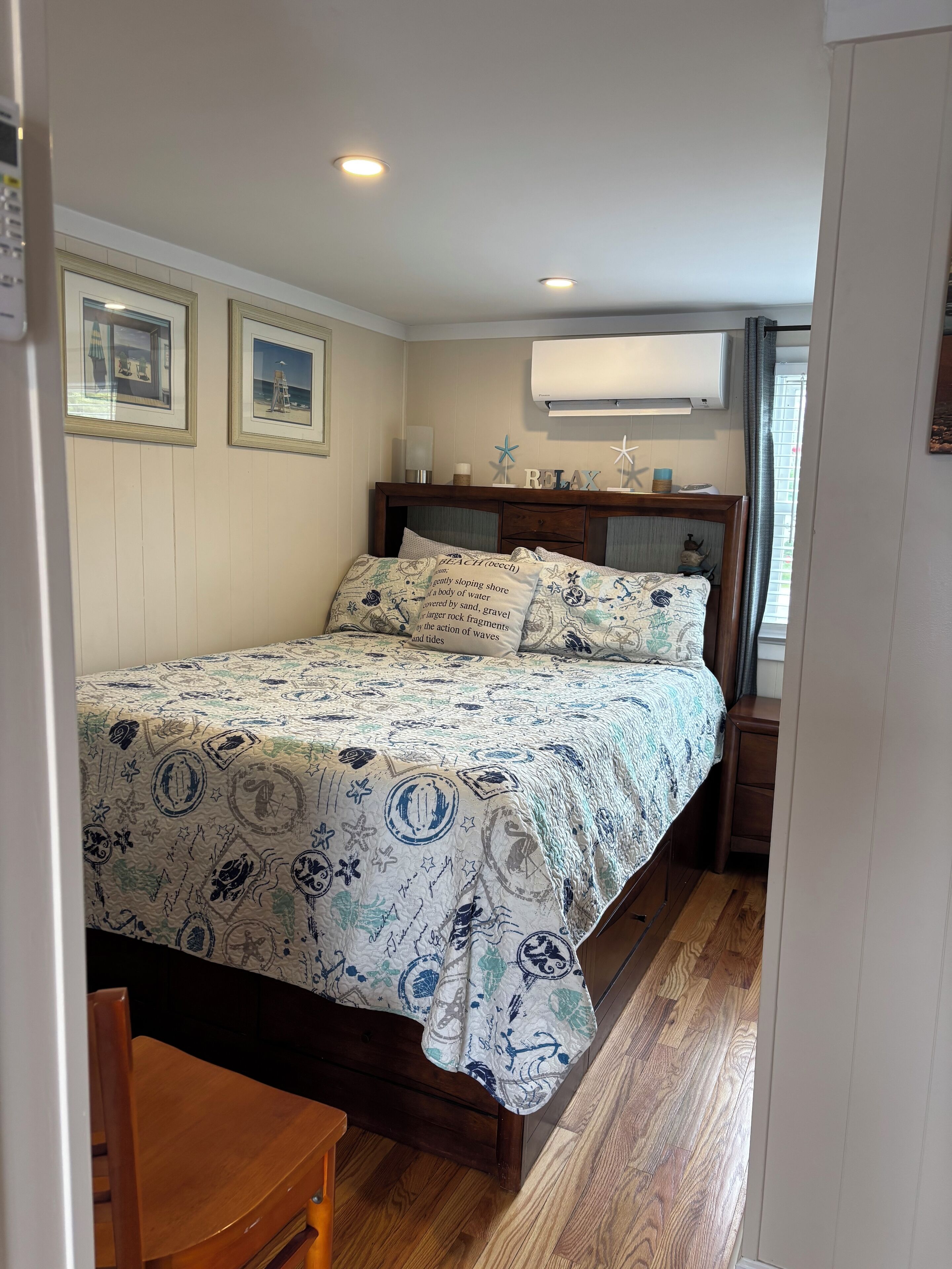 A bedroom with a bed, wooden headboard, and a nightstand.
