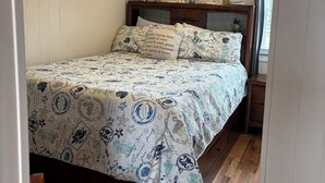 A bedroom with a bed, wooden headboard, and a nightstand. - Oceanview! Cozy Condo with Kitchen, Living Area, Porch, 2 Reserved Parking Spots (Old Orchard Beach)