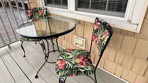A glass-top table with two chairs on a wooden deck. - Oceanview! Cozy Condo with Kitchen, Living Area, Porch, 2 Reserved Parking Spots (Old Orchard Beach)