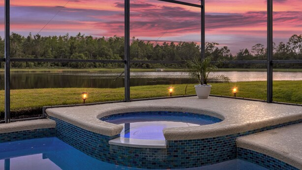 Een hottub met uitzicht op een meer en een zonsondergang.